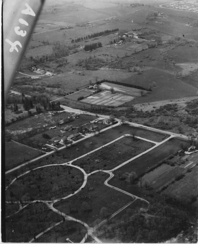 An aerial view of fields and roads in a cemetery across from Cherryhill
